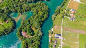 ein Luftblick auf einen Fluss mit Häusern und Wäldern in der Unterkunft Villa UNA LUX in Bihać