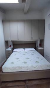 - une chambre avec un grand lit et des placards blancs dans l'établissement Luminoso Bilocale zona Tibaldi Bocconi, à Milan