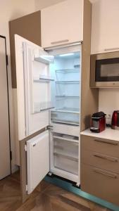 - un réfrigérateur avec une porte ouverte dans la cuisine dans l'établissement Luminoso Bilocale zona Tibaldi Bocconi, à Milan
