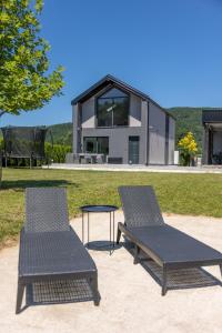 two chairs and a table in front of a house at Villa UNA LUX in Bihać