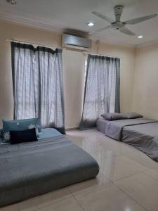 two beds in a room with windows and curtains at Homestay GG Greenwood Gombak in Batu Caves