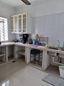 a kitchen with white cabinets and a large counter top at Homestay GG Greenwood Gombak in Batu Caves