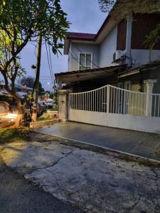a house with a white fence and a driveway at Homestay GG Greenwood Gombak in Batu Caves
