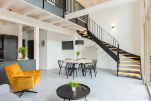 a living room with a table and chairs and a staircase at Ferienhaus MOSELLODGE in Enkirch