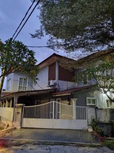 a house with a white fence in front of it at Homestay GG Greenwood Gombak in Batu Caves