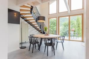 a dining room with a table and chairs and a spiral staircase at Ferienhaus MOSELLODGE in Enkirch