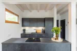a kitchen with black cabinets and a counter top at Ferienhaus MOSELLODGE in Enkirch +11 photos