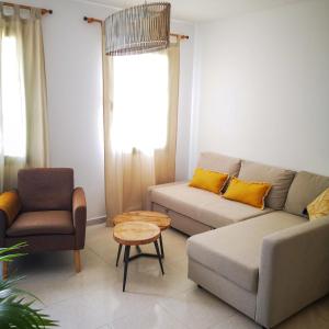 ein Wohnzimmer mit einem Sofa und einem Stuhl in der Unterkunft Apartamentos Mares de Lava - Playa Blanca in Playa Blanca