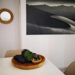 Un bol de fruta sobre una mesa con una pintura. en Apartamentos Mares de Lava - Playa Blanca, en Playa Blanca