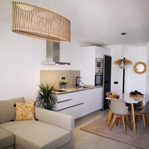 Una cocina y una sala de estar con un sofá y una mesa. en Apartamentos Mares de Lava - Playa Blanca, en Playa Blanca