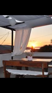 a table with an umbrella with the sunset in the background at Apartments Maja in Lopar