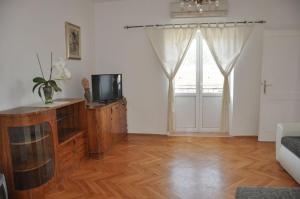 a living room with a television and a window at Apartments Maja in Lopar