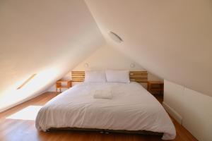 a bedroom with a white bed in a attic at Scottish countryside Bothy in Arbroath