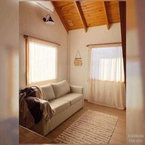 a living room with a couch and a window at La casita suereña in Esquel