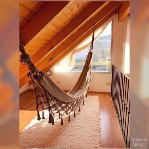 a hammock in a room with a window at La casita suereña in Esquel