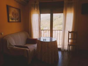 a living room with a table and a window at El Balcon De Cabezuela Valle del Jerte in Cabezuela del Valle