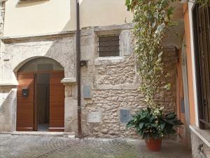 un edificio de piedra con una puerta y una maceta en La casetta di Bianca en Sulmona