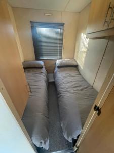 two beds in a small room with a window at Shear water in Morecambe