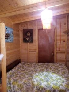 un dormitorio con una cama y una foto de un hombre en Cabaña Felipe Kaluf, en Constitución