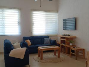 a living room with a blue couch and a table at GoBaja Villas 3 bedroom in La Paz