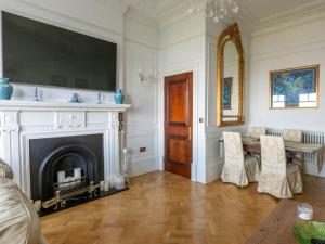 a living room with a fireplace and a table and chairs at Walpole View - Balcony Apartment - Stunning Seafront Views -TV over bath -2mins beach in Kent