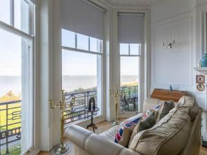 a living room with a couch and large windows at Walpole View - Balcony Apartment - Stunning Seafront Views -TV over bath -2mins beach in Kent