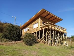Cabaña de madera en una colina con cielo azul en Cabaña Felipe Kaluf, en Constitución