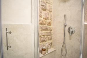 a shower with a glass door in a bathroom at Monolocale centro storico in Gubbio +8 photos