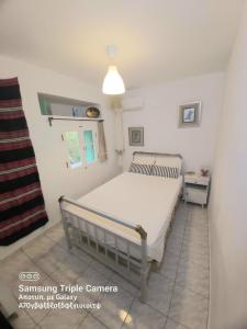 Schlafzimmer mit einem Bett und einem Fenster in der Unterkunft Charming house with stunning view in Arvanitakaíïka