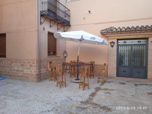 a patio with a table with an umbrella and chairs at Señorio de Quevedo in Villanueva de los Infantes