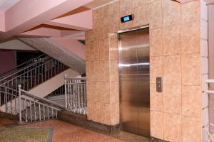 a metal elevator in a building with stairs at Modern & Homely Suite with Free Parking & WiFi in Embu