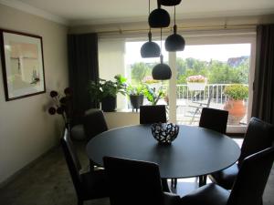 comedor con mesa, sillas y ventana en Residentie Kathy Westende, en Middelkerke