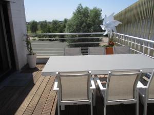 - Balcón con mesa blanca y sillas en Residentie Kathy Westende, en Middelkerke