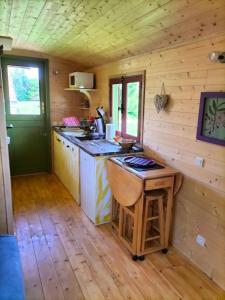 a kitchen in a log cabin with a table and a stove at Jolie Roulotte in Issendolus