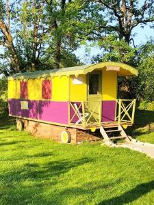 a colorful house sitting in a field of grass at Jolie Roulotte in Issendolus