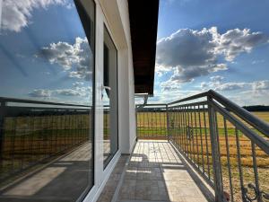 un balcón de una casa con vistas a un campo en Beocinska Kapija, en Rakovac