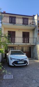 un coche blanco estacionado frente a una casa en Danilo's Appartments, en Koper