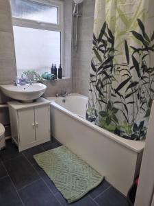 a bathroom with a tub and a sink and a shower curtain at 2 bed luxury flat in Lambeth in London