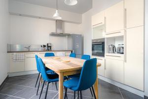 a kitchen with a wooden table and blue chairs at Coeur de ville #B2 - Centre ville, WIFI & NETFLIX - Proche transports - CHAMBRE PRIVEE dans logement partagé in Cholet