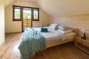 a bedroom with a large bed with a wooden headboard at Willa Vistula DOMKI na WYŁĄCZNOŚĆ in Wisła