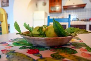 un tazón de manzanas verdes sobre una mesa en Casa Acqua Veccia, en Noto 6 fotos más
