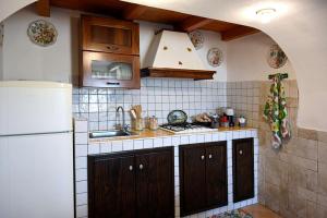 Una cocina con fregadero y refrigerador blanco. en Casa Acqua Veccia, en Noto