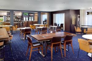 a restaurant with tables and chairs and a bar at Courtyard by Marriott Myrtle Beach Broadway in Myrtle Beach