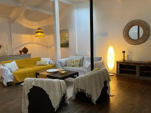 sala de estar con sofá amarillo y mesa en Artist's Home - Villa & Private Courtyard - 200m2, en París