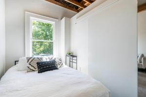 a bedroom with white walls and a bed with pillows at The 505 Eugene in Eugene