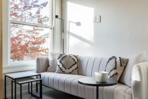 un divano bianco in un soggiorno con finestra di The 505 Eugene a Eugene