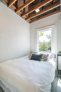 a bedroom with a white bed and a window at The 505 Eugene in Eugene