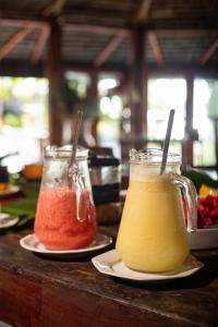 dos jarras de diferentes bebidas de colores en platos en una mesa en Indaiá Eco Village, en Ilhéus
