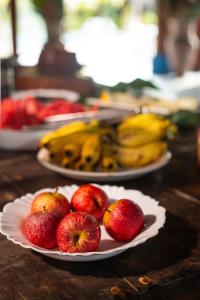dwie talerze jabłek i bananów na stole w obiekcie Indaiá Eco Village w mieście Ilhéus