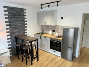 a kitchen with a table and a stainless steel refrigerator at White and Black Apartments in Katowice